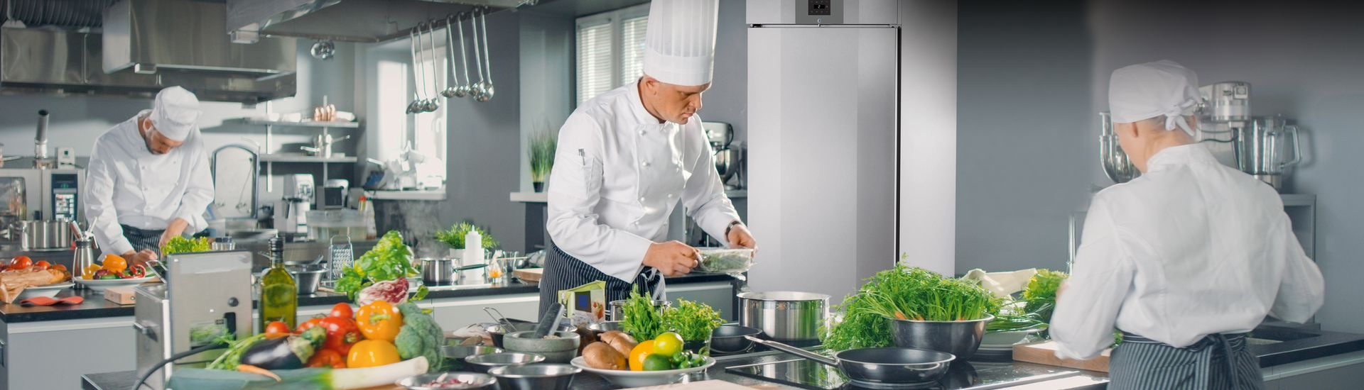 chefs qui préparent des plats dans une cuisine professionnelle